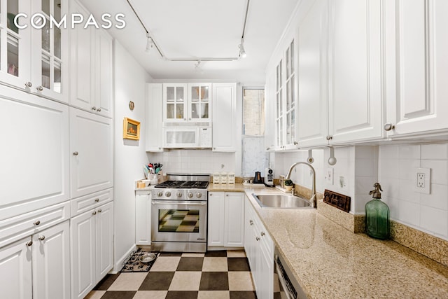 50 W 67th St Unit 4F, New York City, NY 10023 - kitchen featuring stainless steel gas range, white microwave, a sink, and white cabinetry