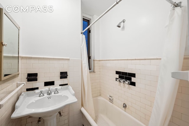 50 W 67th St Unit 4E, New York City, NY 10023 - full bathroom with tile walls, wainscoting, shower / tub combo with curtain, and a sink
