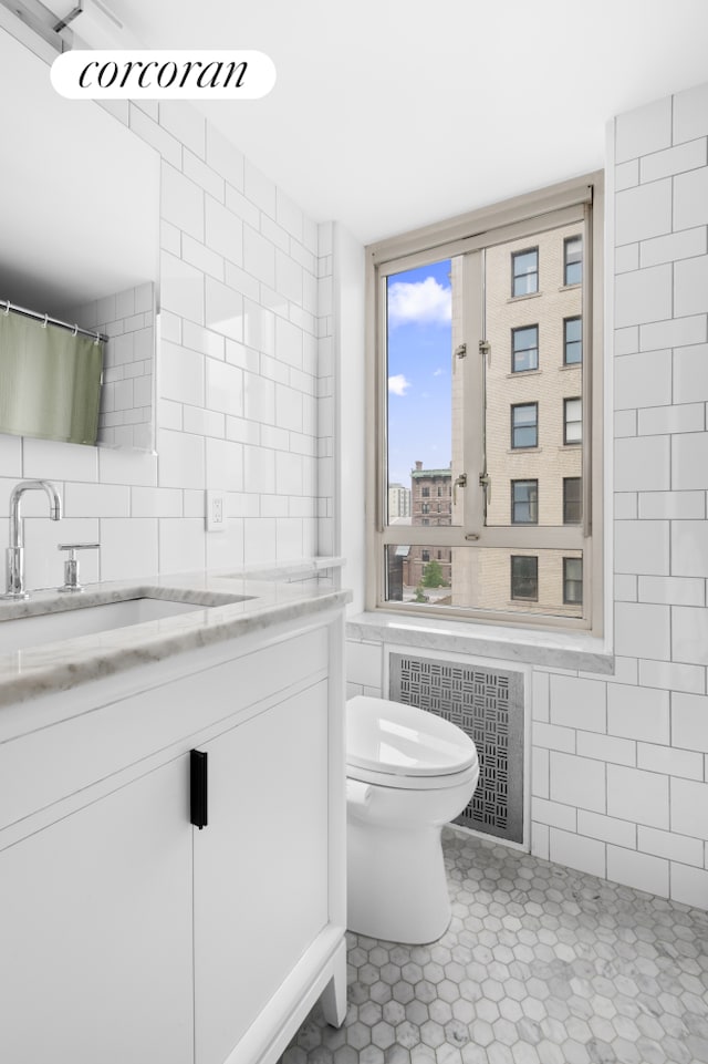 60 Remsen St Unit 9A, New York City, NY 11201 - full bath featuring tile walls, vanity, tile patterned flooring, radiator heating unit, and backsplash