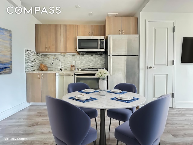 28-20 Astoria Blvd Unit 4, New York City, NY 11102 - kitchen with stainless steel appliances, light countertops, tasteful backsplash, and light wood-style floors