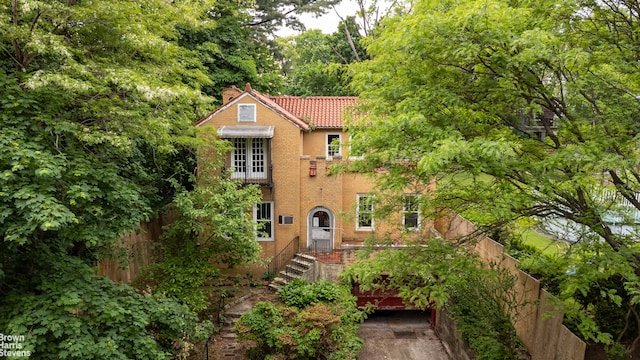 3115 Netherland Ave, New York City, NY 10463 - view of front of house featuring a tile roof, a chimney, and stucco siding