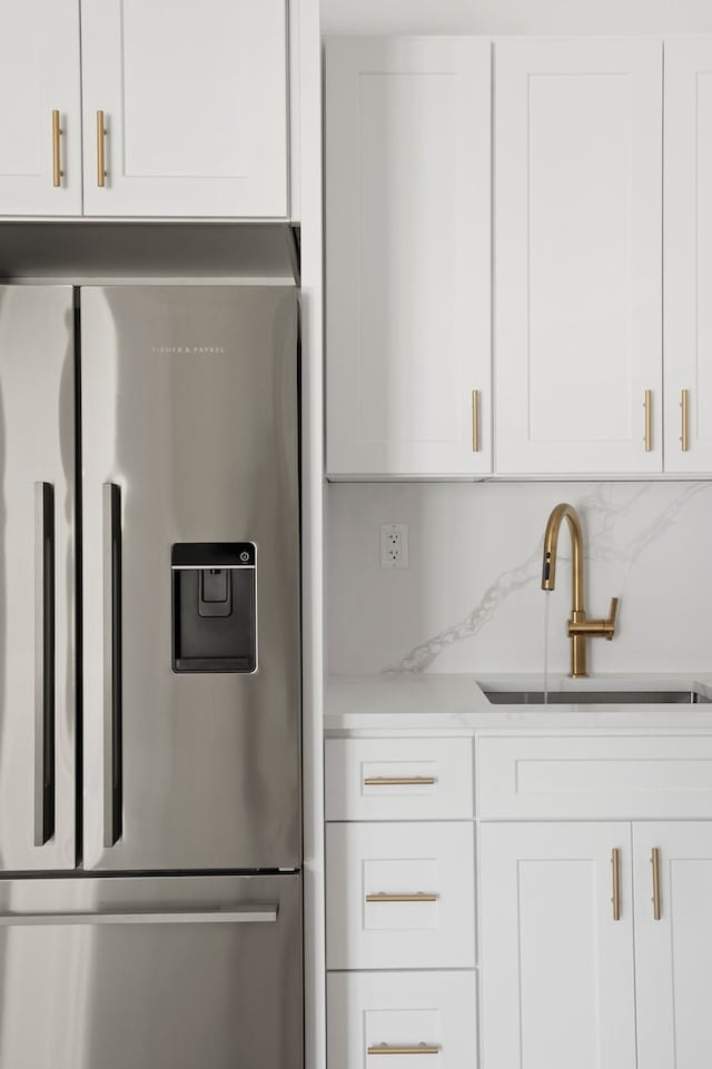 78 Harman St Unit 2-R, New York City, NY 11221 - kitchen with stainless steel fridge with ice dispenser, a sink, and white cabinetry
