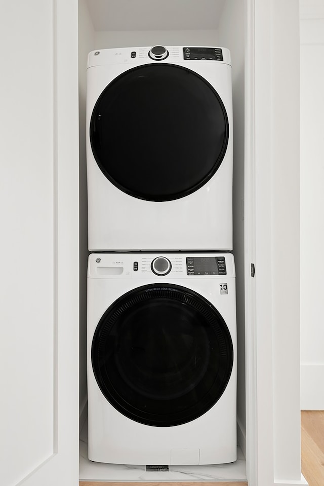 78 Harman St Unit 2-F, New York City, NY 11221 - washroom with stacked washer and clothes dryer and wood finished floors