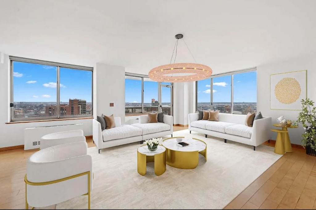 200 E 89th St Unit 42-Cn, New York City, NY 10128 - living room featuring wood finished floors, radiator heating unit, and a wall of windows