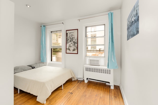 206 E 35th St Unit Th, New York City, NY 10016 - bedroom with radiator, light wood-style floors, cooling unit, and baseboards