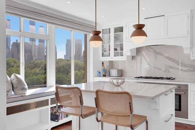 3 E 71st St Unit 10/11B, New York City, NY 10021 - kitchen featuring decorative backsplash, a kitchen island, glass insert cabinets, white cabinets, and recessed lighting