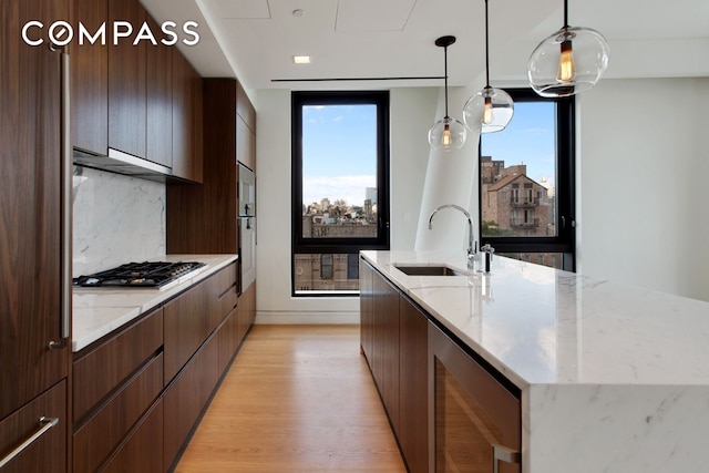 242 Broome St Unit 7D, New York City, NY 10002 - kitchen with a sink, modern cabinets, wine cooler, and a kitchen island with sink