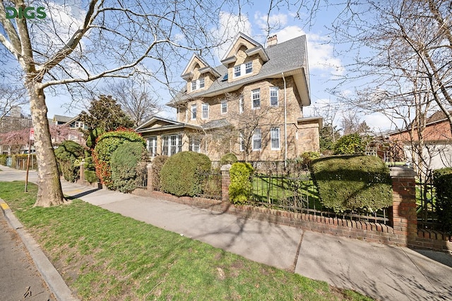 685 E 22nd St, New York City, NY 11210 - view of front of house with a fenced front yard, stone siding, and a chimney