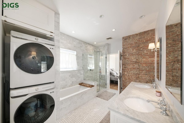 685 E 22nd St, New York City, NY 11210 - full bath with estacked washer and dryer, a bath, double vanity, a stall shower, and recessed lighting