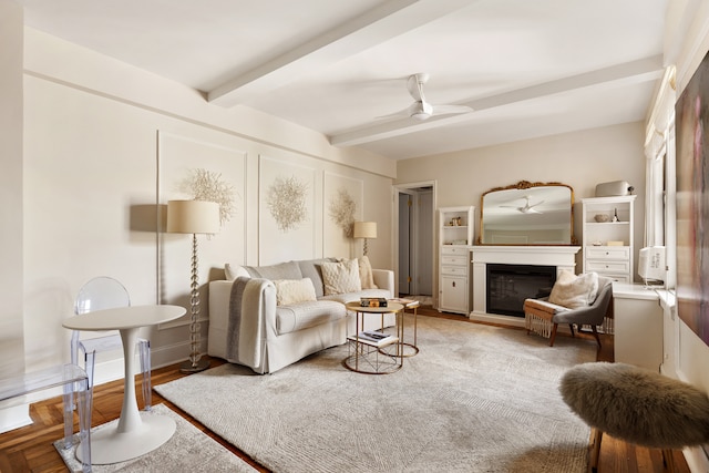 74 W 68th St Unit 7F, New York City, NY 10023 - living room with beamed ceiling, ceiling fan, a glass covered fireplace, and wood finished floors