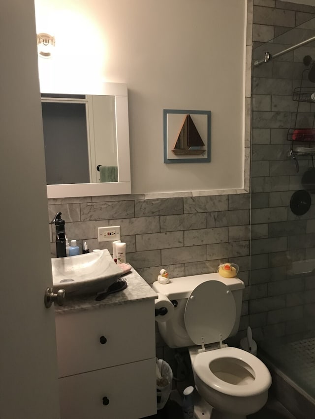 225 E 86th St Unit 304, New York City, NY 10028 - full bath featuring vanity, tile walls, a shower stall, toilet, and a wainscoted wall