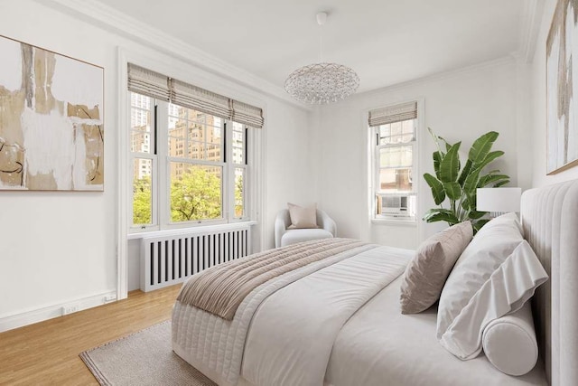 150 E 72nd St Unit 6S, New York City, NY 10021 - bedroom featuring radiator, crown molding, wood finished floors, and baseboards