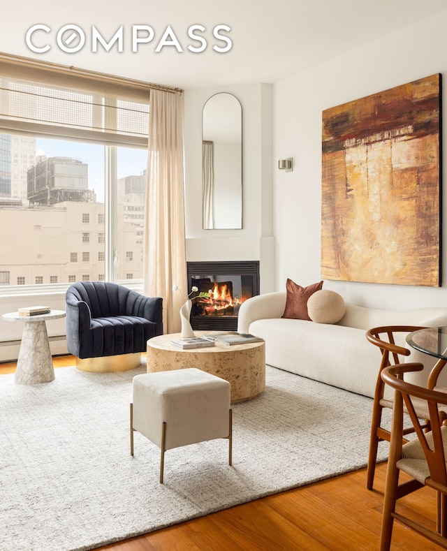 205 E 59th St Unit 14B, New York City, NY 10022 - living room featuring wood finished floors, a glass covered fireplace, and a city view