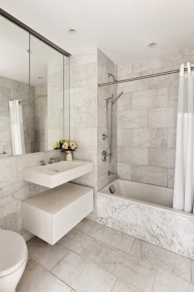 15 W 61st St Unit 12G, New York City, NY 10023 - bathroom with tiled shower / bath combo, tile walls, marble finish flooring, toilet, and vanity