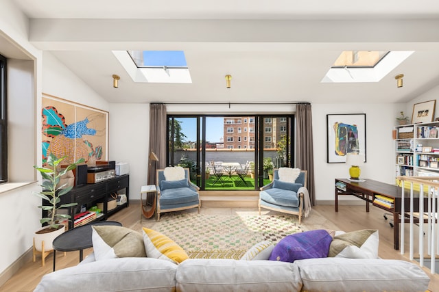 15 Jones St Unit 6A, New York City, NY 10014 - living area with a skylight, lofted ceiling, light wood-style floors, and baseboards