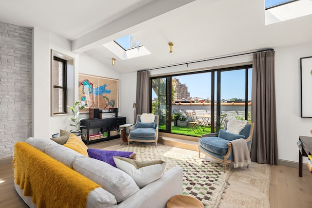 15 Jones St Unit 6A, New York City, NY 10014 - living room featuring a skylight, plenty of natural light, wood finished floors, a water view, and brick wall