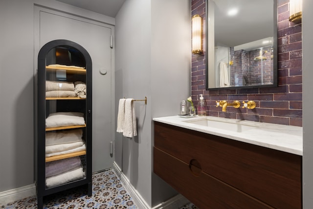 15 Jones St Unit 6A, New York City, NY 10014 - bathroom featuring vanity, decorative backsplash, baseboards, and tile patterned floors