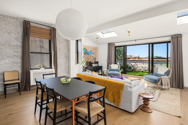 15 Jones St Unit 6A, New York City, NY 10014 - dining area with a skylight, light wood-type flooring, a water view, lofted ceiling, and brick wall
