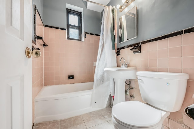 263 Bennett Ave Unit 1C, New York City, NY 10040 - full bathroom with shower / bathtub combination with curtain, tile walls, toilet, tile patterned flooring, and wainscoting