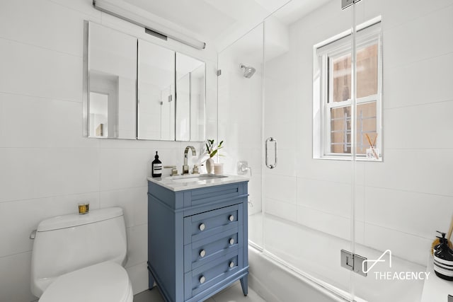 130 E 63rd St Unit 4E, New York City, NY 10065 - bathroom with vanity, shower / bath combination with glass door, and tile walls