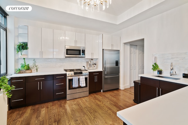200 Rector Pl Unit 44D, New York City, NY 10280 - kitchen with appliances with stainless steel finishes, white cabinetry, backsplash, light countertops, and a chandelier