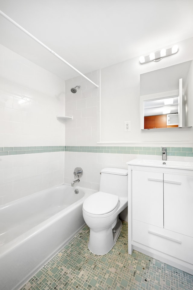 184 Thompson St Unit 5B, New York City, NY 10012 - bathroom featuring tile walls, toilet, vanity, tub / shower combination, and tile patterned floors