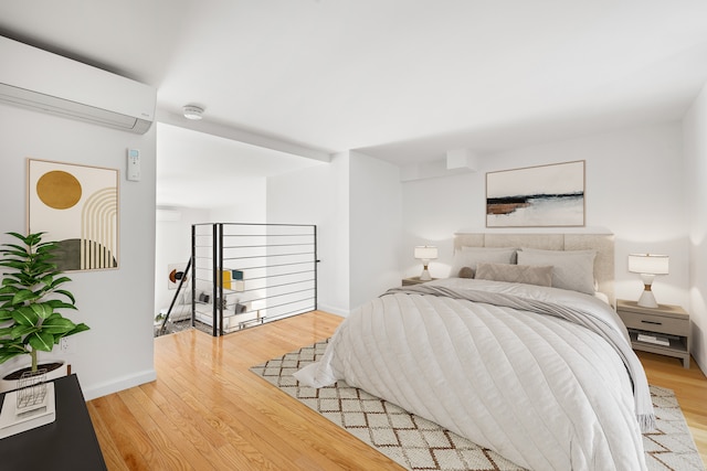 184 Thompson St Unit 5B, New York City, NY 10012 - bedroom featuring a wall unit AC, light wood-type flooring, and baseboards