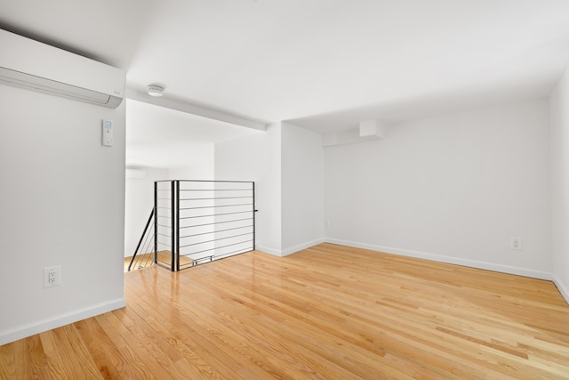 184 Thompson St Unit 5B, New York City, NY 10012 - unfurnished room featuring a wall mounted AC, wood finished floors, and baseboards