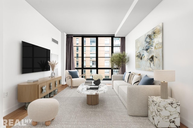 261 W 25th St Unit 8A, New York City, NY 10001 - living room with a wall of windows, wood finished floors, and baseboards