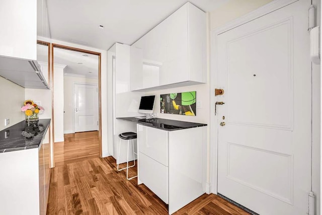 25 E End Ave Unit 10E, New York City, NY 10075 - kitchen with white cabinetry, wood finished floors, crown molding, and modern cabinets
