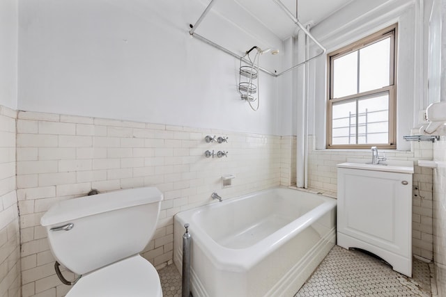 170 W 74th St Unit 505, New York City, NY 10023 - full bathroom with tile walls, toilet, wainscoting, vanity, and tile patterned floors