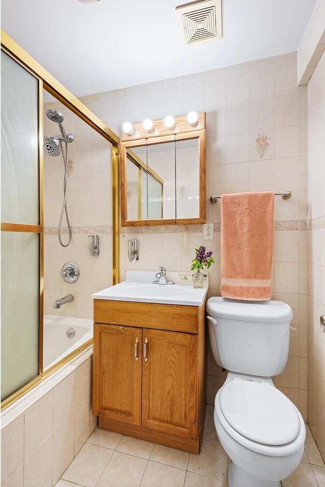 400 E 17th St Unit 608, New York City, NY 11226 - bathroom featuring tile walls, tiled shower / bath, toilet, vanity, and tile patterned flooring