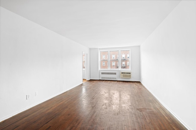 400 E 17th St Unit 608, New York City, NY 11226 - unfurnished room with radiator heating unit, dark wood-style flooring, a wall mounted AC, and baseboards