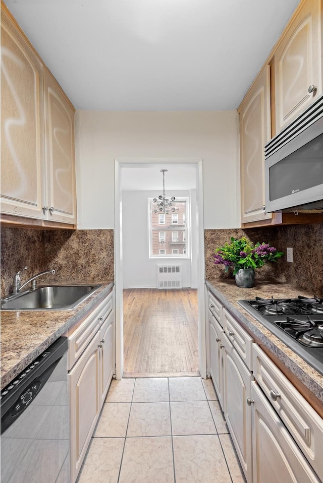 400 E 17th St Unit 608, New York City, NY 11226 - kitchen featuring stainless steel appliances, a sink, a chandelier, light tile patterned flooring, and decorative backsplash