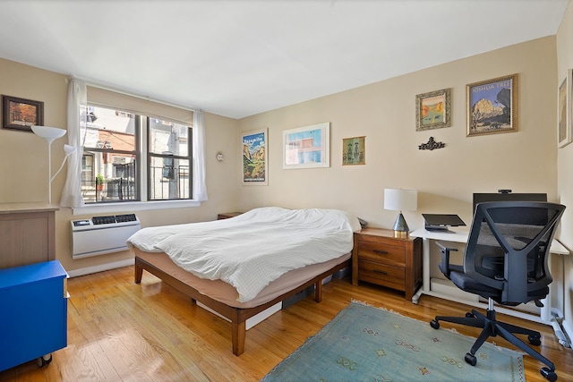 439 E 88th St Unit 5B, New York City, NY 10128 - bedroom featuring an AC wall unit, wood finished floors, and an office area