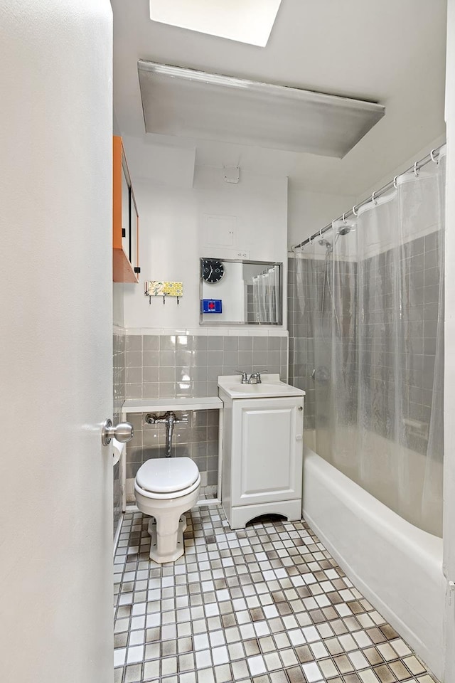 439 E 88th St Unit 5B, New York City, NY 10128 - full bathroom with tile walls, toilet, shower / bathtub combination with curtain, vanity, and wainscoting