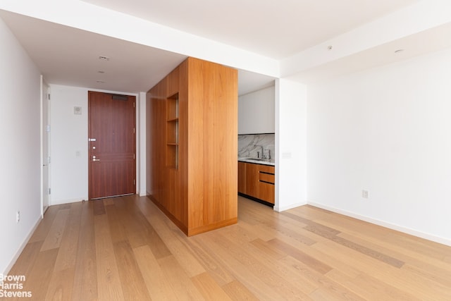 1 W End Ave Unit 18H, New York City, NY 10023 - empty room with light wood-style flooring, a sink, and baseboards