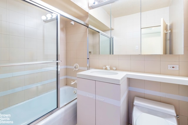 20 W 64th St Unit 20K, New York City, NY 10023 - full bathroom with tile walls, shower / bath combination with glass door, and vanity