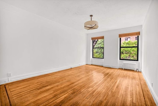 26 W 97th St Unit 3A, New York City, NY 10025 - spare room with radiator heating unit, light wood-type flooring, and baseboards