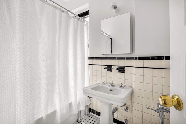 26 W 97th St Unit 3A, New York City, NY 10025 - bathroom with tile walls, shower / tub combo with curtain, and wainscoting