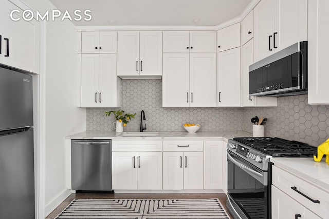 72-17 34th Ave Unit 1P, New York City, NY 11372 - kitchen featuring appliances with stainless steel finishes, white cabinetry, tasteful backsplash, and light stone counters