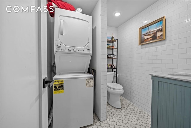 1509 Dean Street Multi, New York City, NY 11213 - laundry room featuring stacked washing machine and dryer, light tile patterned floors, and tile walls