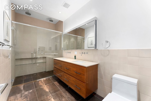 175 E Broadway Unit 8A, New York City, NY 10002 - full bathroom featuring tile walls, vanity, a shower stall, and toilet