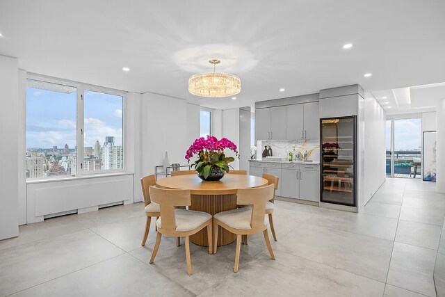 422 E 72nd St Unit 37Ad, New York City, NY 10021 - dining area with beverage cooler, healthy amount of natural light, a chandelier, recessed lighting, and a view of city