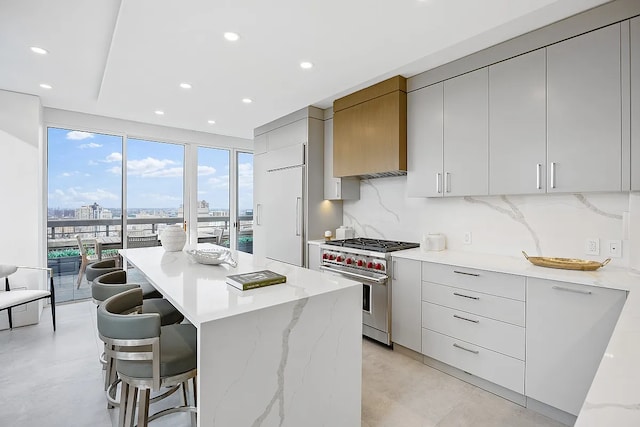 422 E 72nd St Unit 37Ad, New York City, NY 10021 - kitchen with premium appliances, modern cabinets, a center island, a kitchen bar, and decorative backsplash