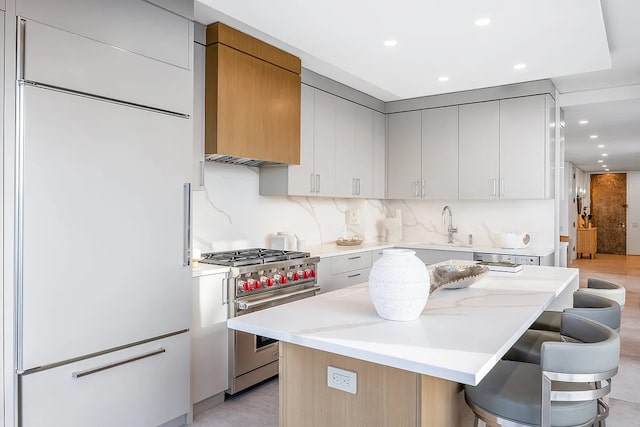 422 E 72nd St Unit 37Ad, New York City, NY 10021 - kitchen featuring high quality appliances, a kitchen breakfast bar, a center island, recessed lighting, and tasteful backsplash