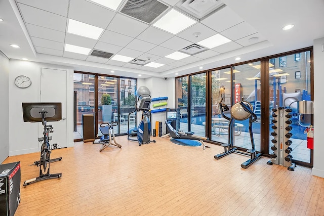 422 E 72nd St Unit 37Ad, New York City, NY 10021 - exercise room featuring a wall of windows, a raised ceiling, wood finished floors, and a paneled ceiling
