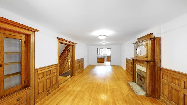 93A Rutland Rd, New York City, NY 11225 - corridor featuring light wood-type flooring, wainscoting, and stairs