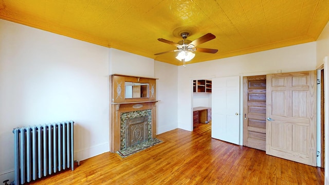 93A Rutland Rd, New York City, NY 11225 - living room with radiator heating unit, ceiling fan, wood finished floors, and a fireplace with flush hearth