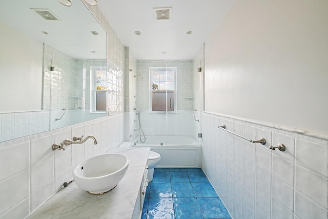 93A Rutland Rd, New York City, NY 11225 - bathroom with tile walls, bath / shower combo with glass door, vanity, tile patterned flooring, and recessed lighting